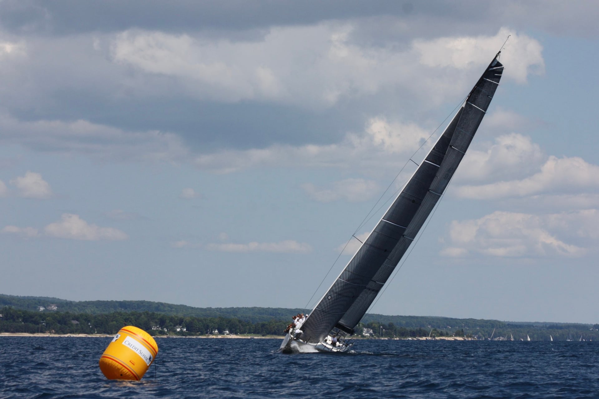 Sailboat racing near a buoy on open water
