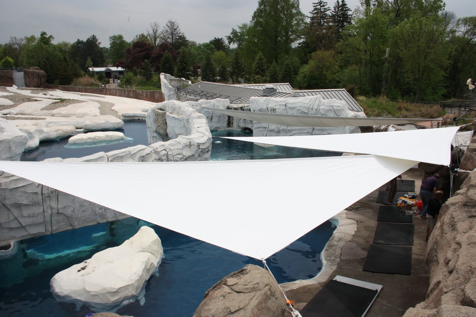 Zoo exhibit with triangular shade sails over rocky pools
