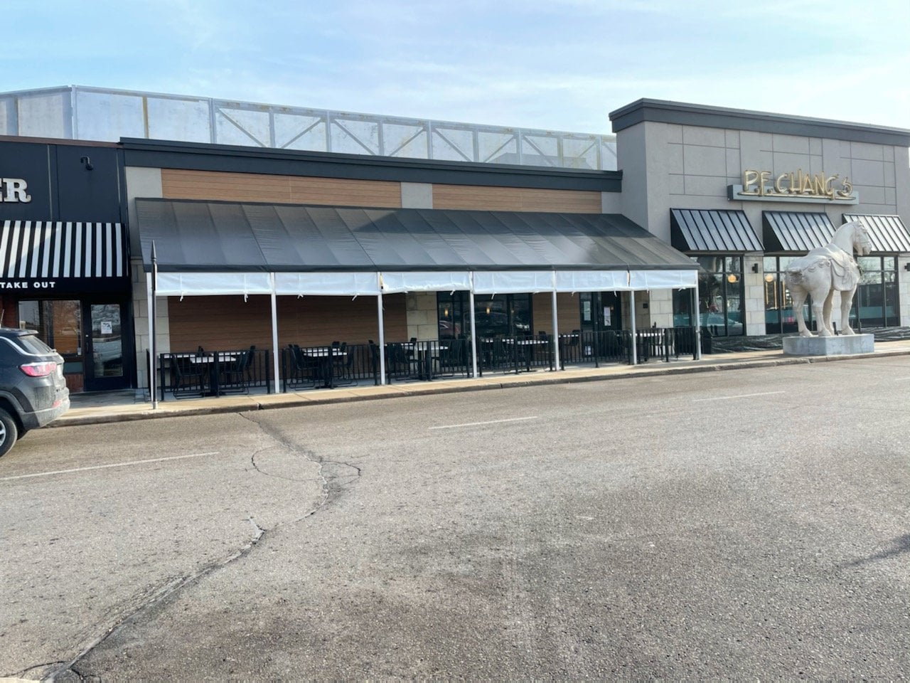 Restaurant patio with outdoor seating and a horse statue
