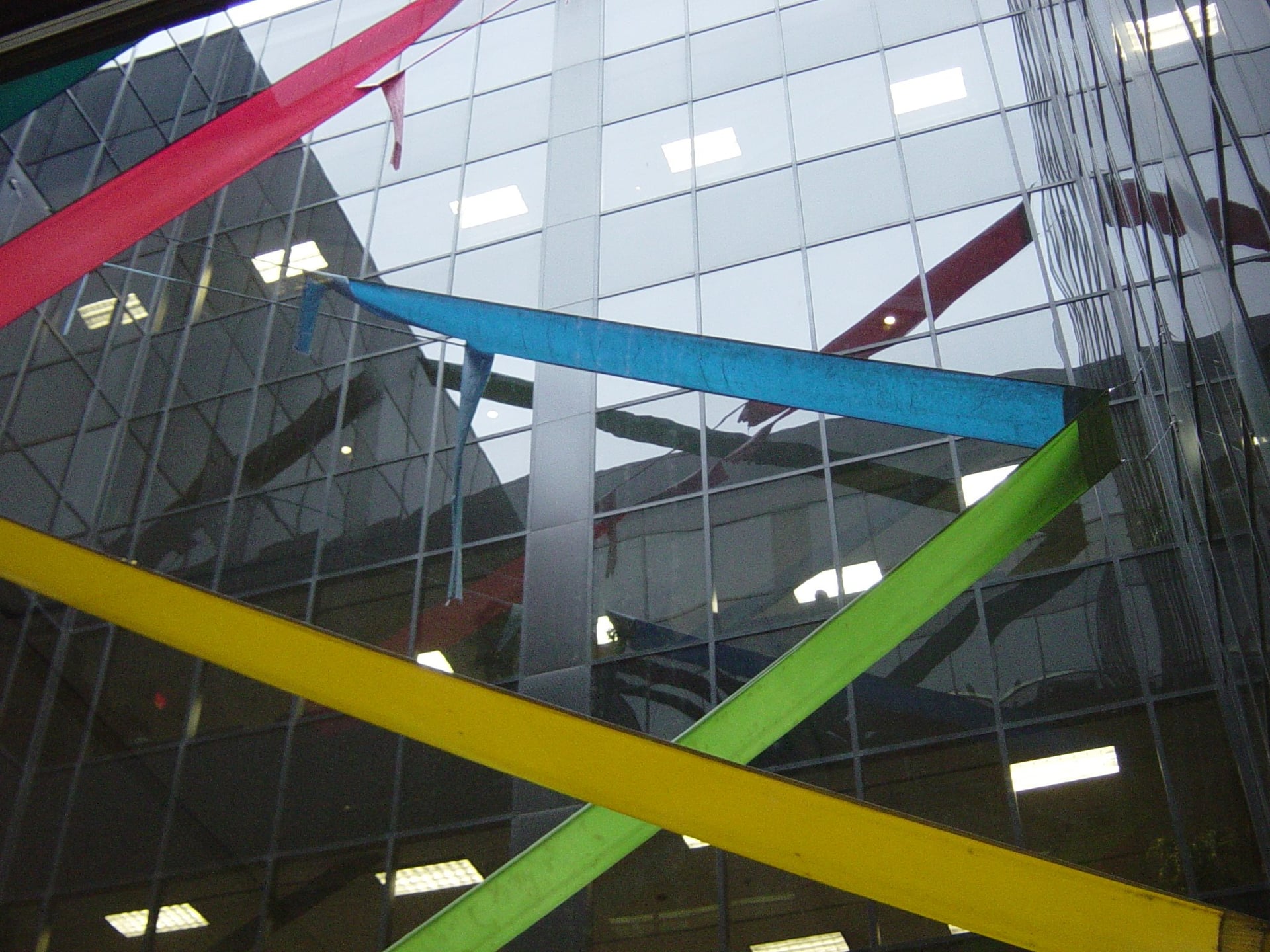 Colorful ribbons hanging in front of a glass building