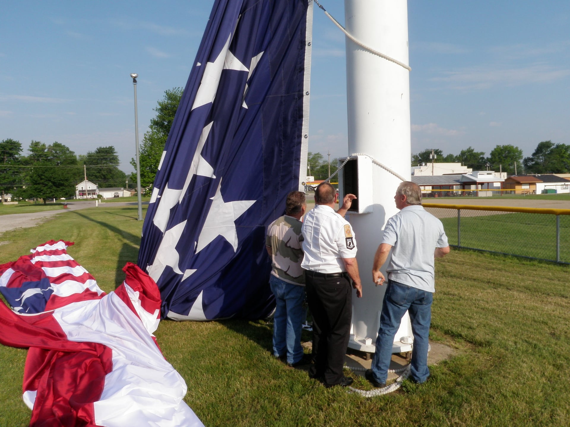 Group of men raising a large American flag