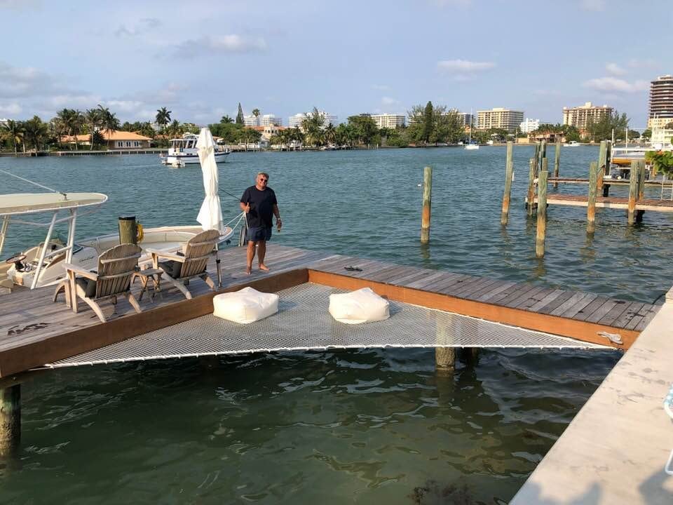 Waterfront dock with a netted lounging area and boats