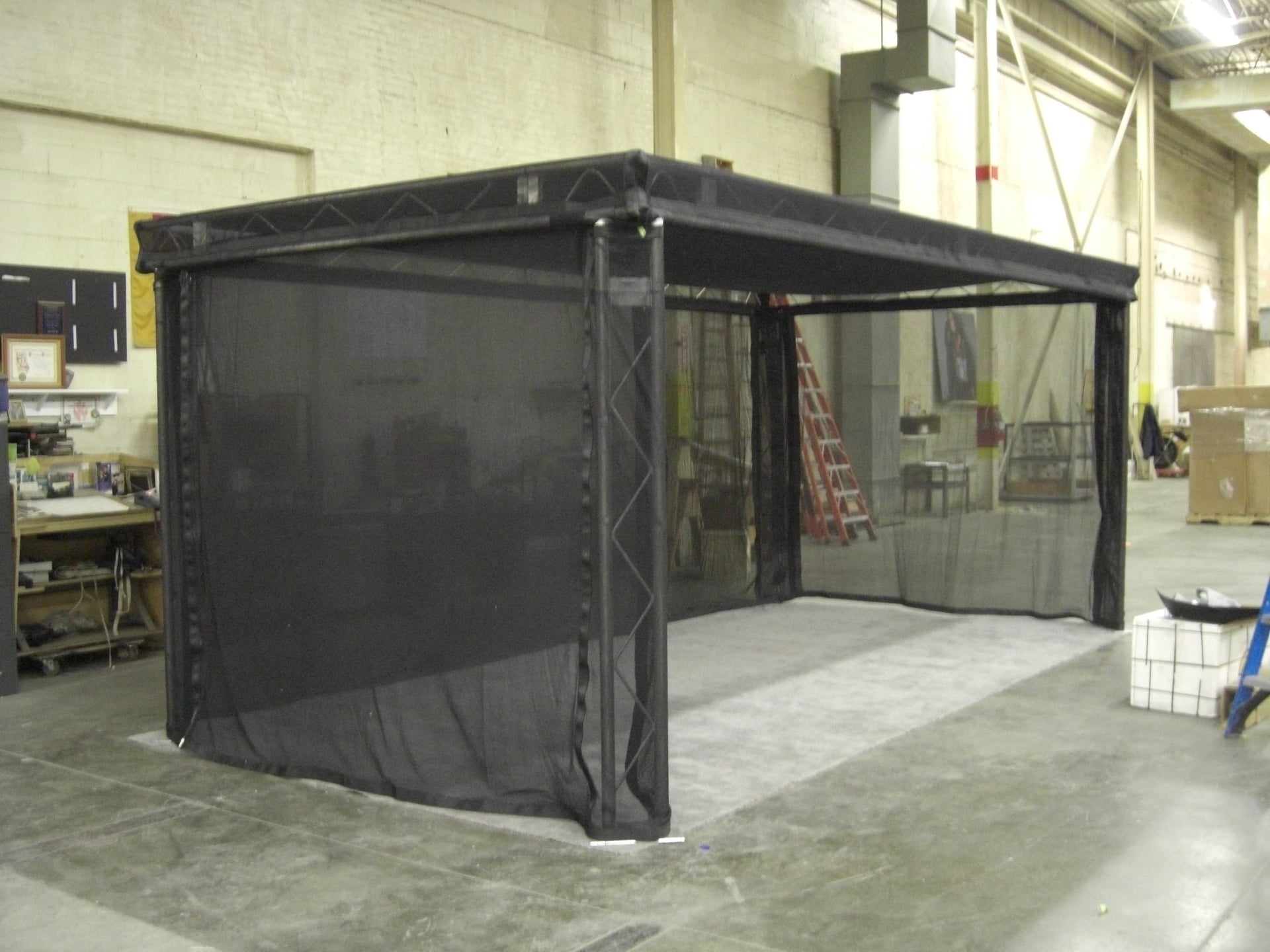 Black fabric enclosure inside an industrial warehouse
