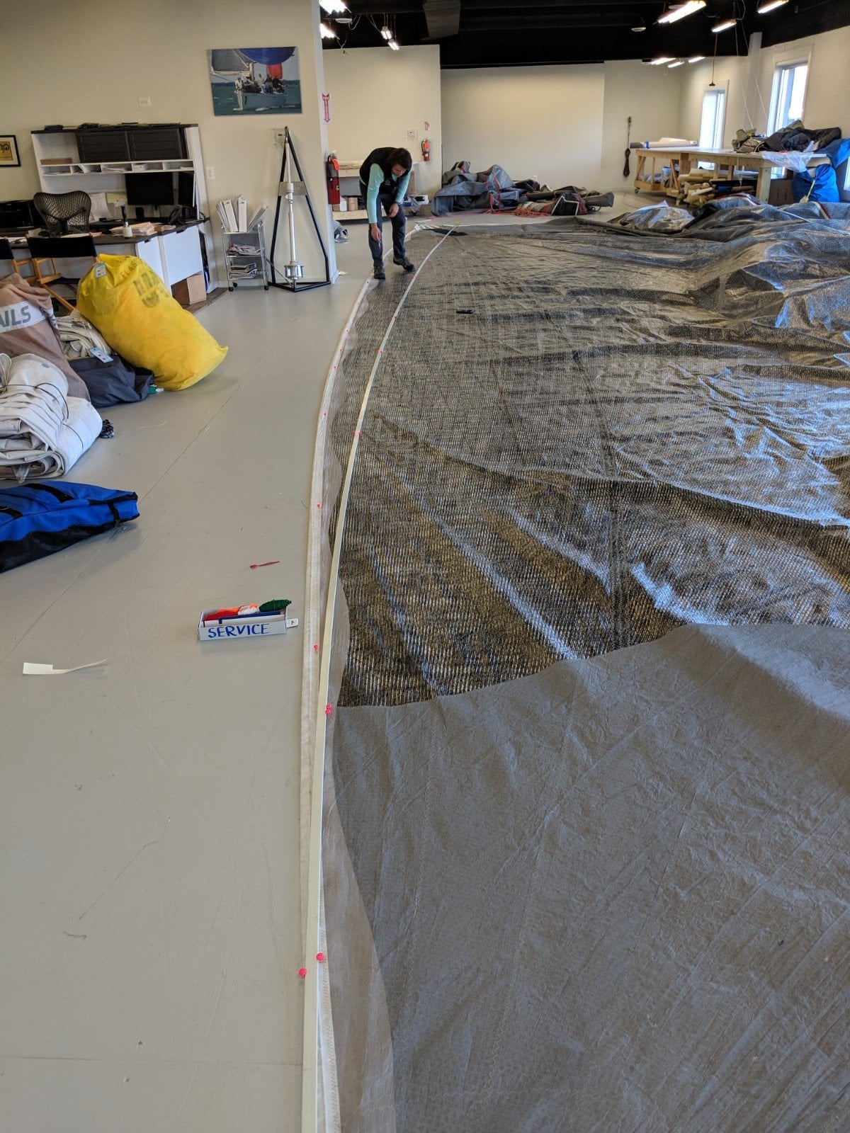 Person working on a large sail in the loft