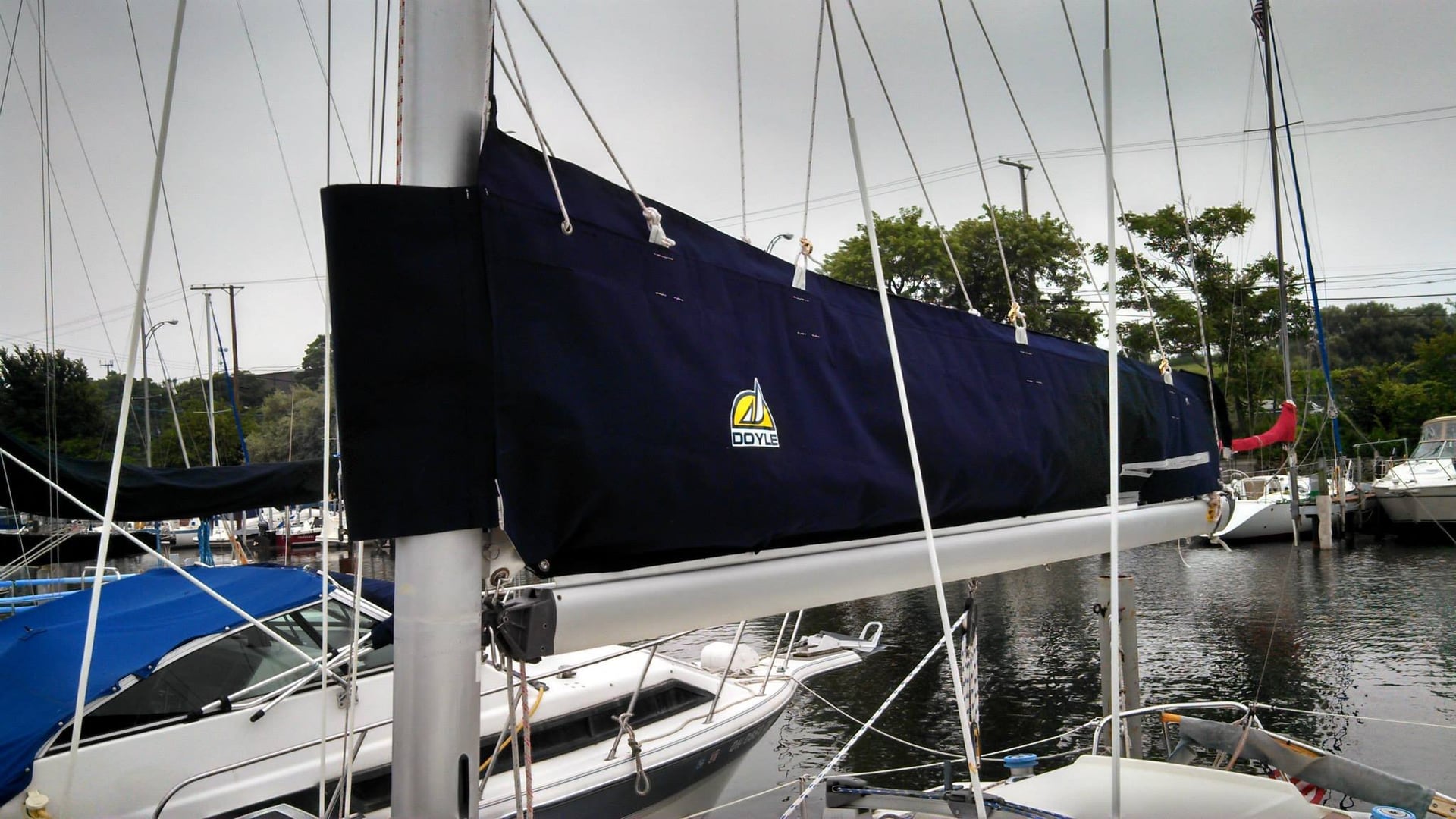 Sailboat mast with a covered sail in a marina