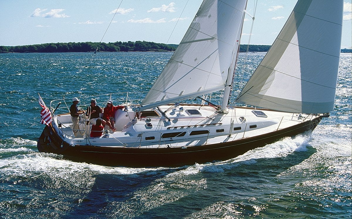 Sailboat with crew underway, flying an American flag